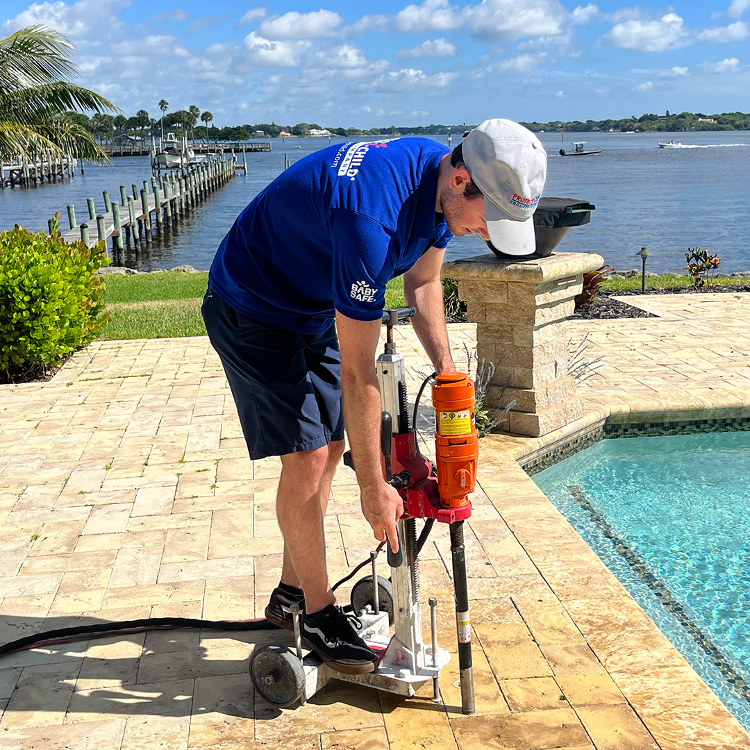 Core-drilling a pool fence deck.